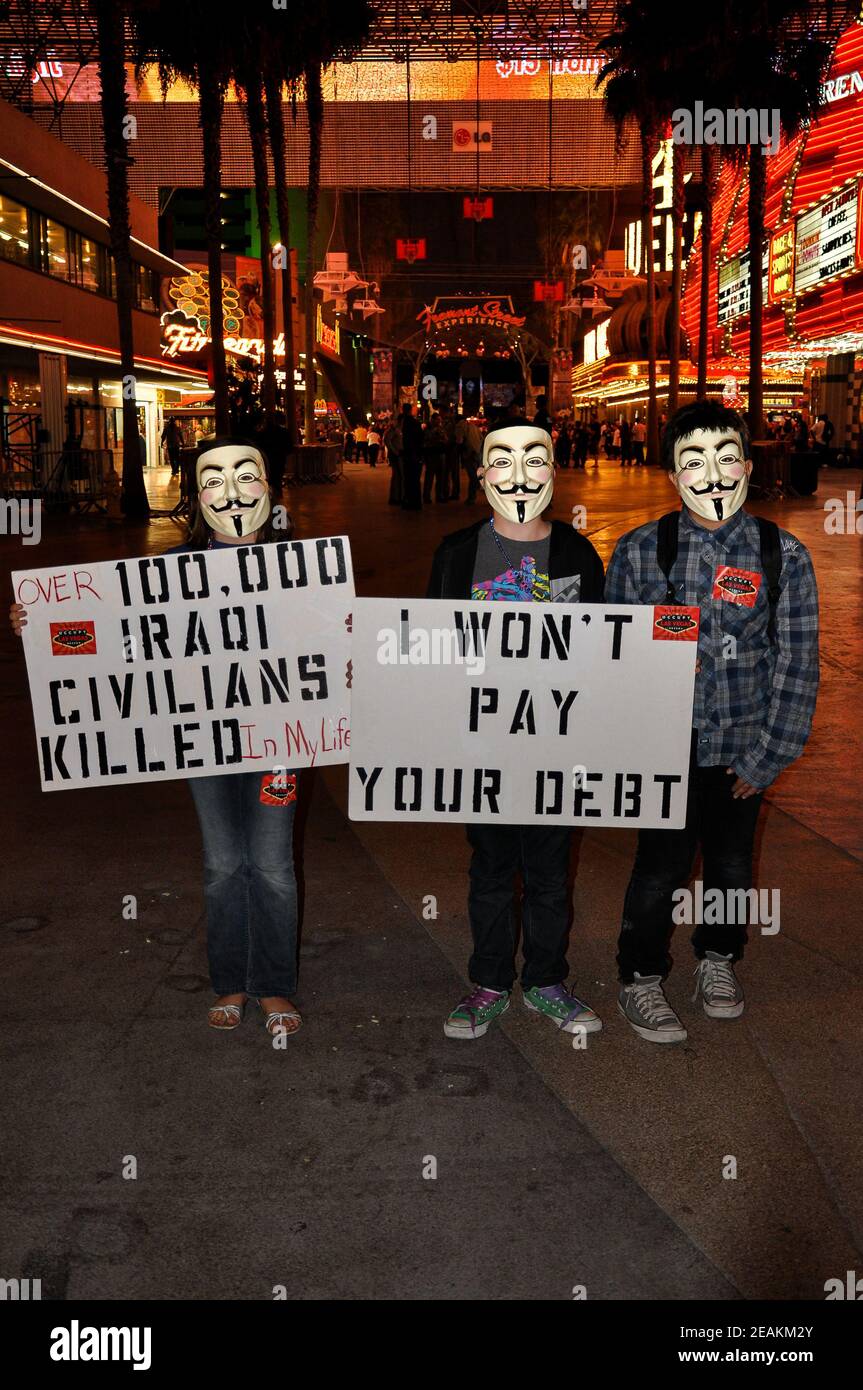 Les manifestants du mouvement Occupy Las Vegas portent des masques Guy Fawkes et tiennent des panneaux de protestation sur Fremont Street à Las Vegas, Nevada, États-Unis. Banque D'Images