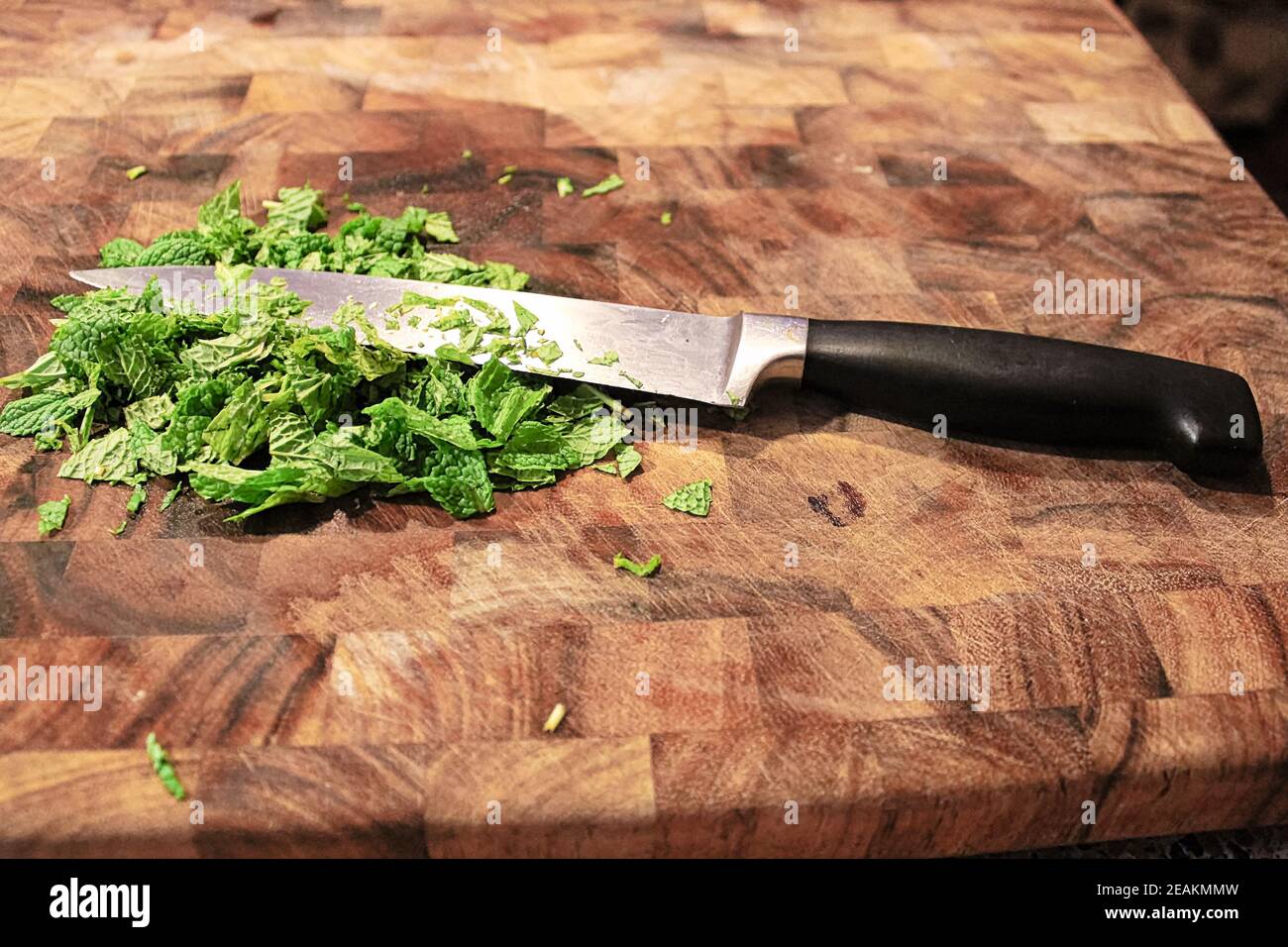 Gros plan d'un couteau sur une planche à découper avec du neuf menthe verte Banque D'Images
