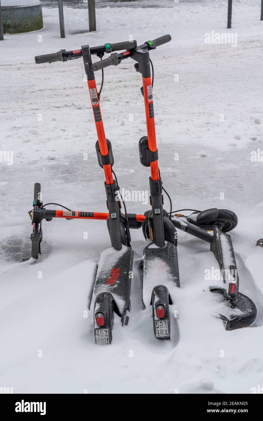 Non utilisés, trottinettes couvertes de neige, scooters électriques, centre-ville d'Essen, Kettwiger Strasse, début de l'hiver, beaucoup de neige fraîche et temperatu de jour Banque D'Images