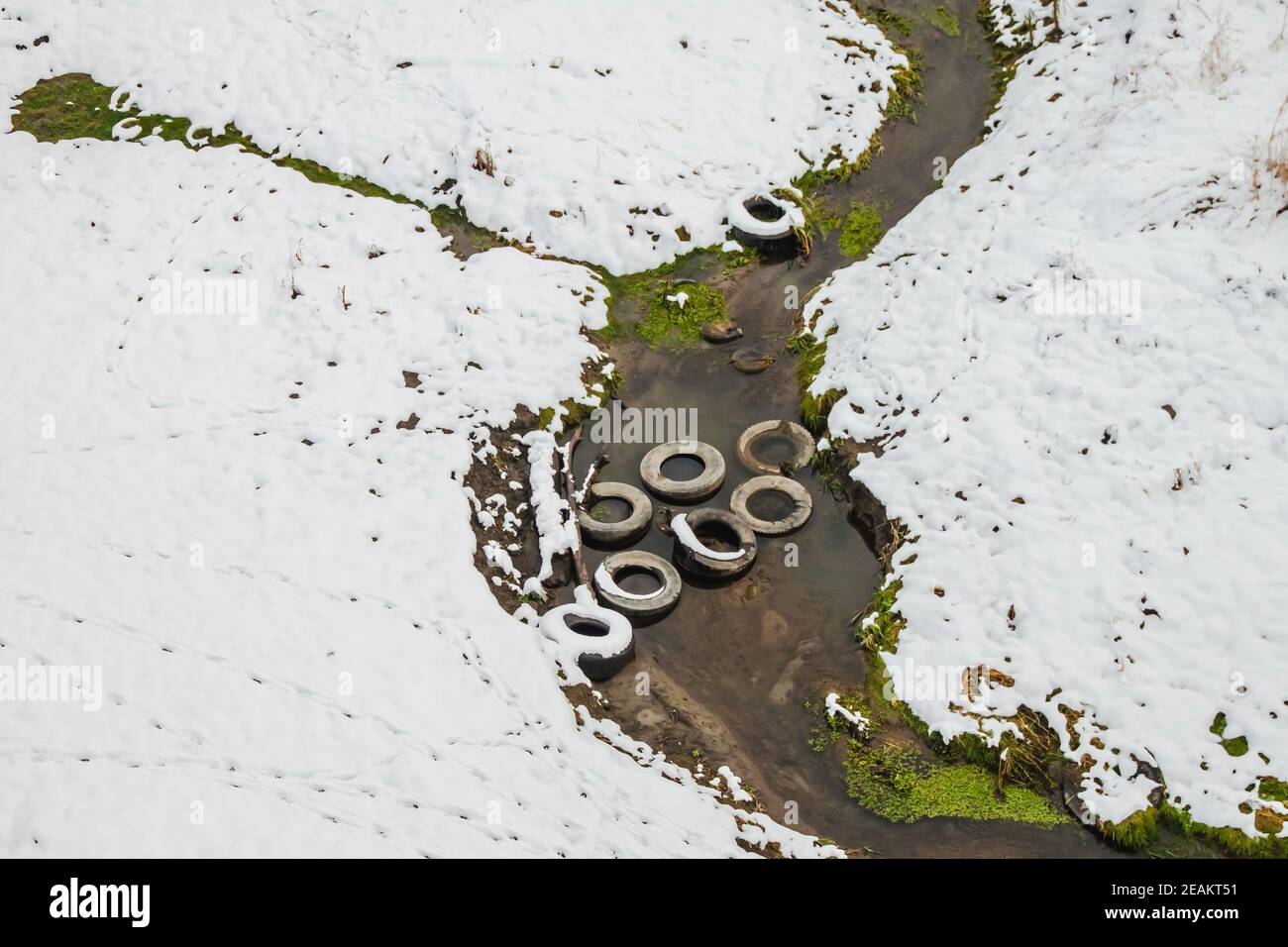 Les vieux pneus de voiture se trouvent dans le cours d'eau qui alimente la rivière. Problèmes environnementaux Banque D'Images
