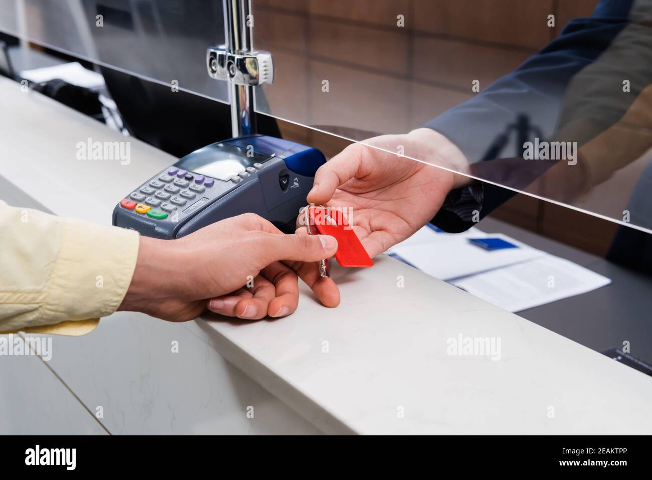 Vue rognée de l'homme prenant la clé du directeur de l'hôtel à hall Banque D'Images