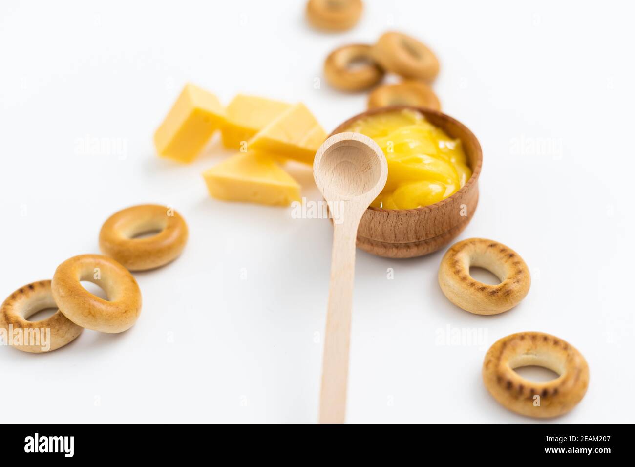 miel dans un bol en bois, bagels et fromage sur fond blanc Banque D'Images