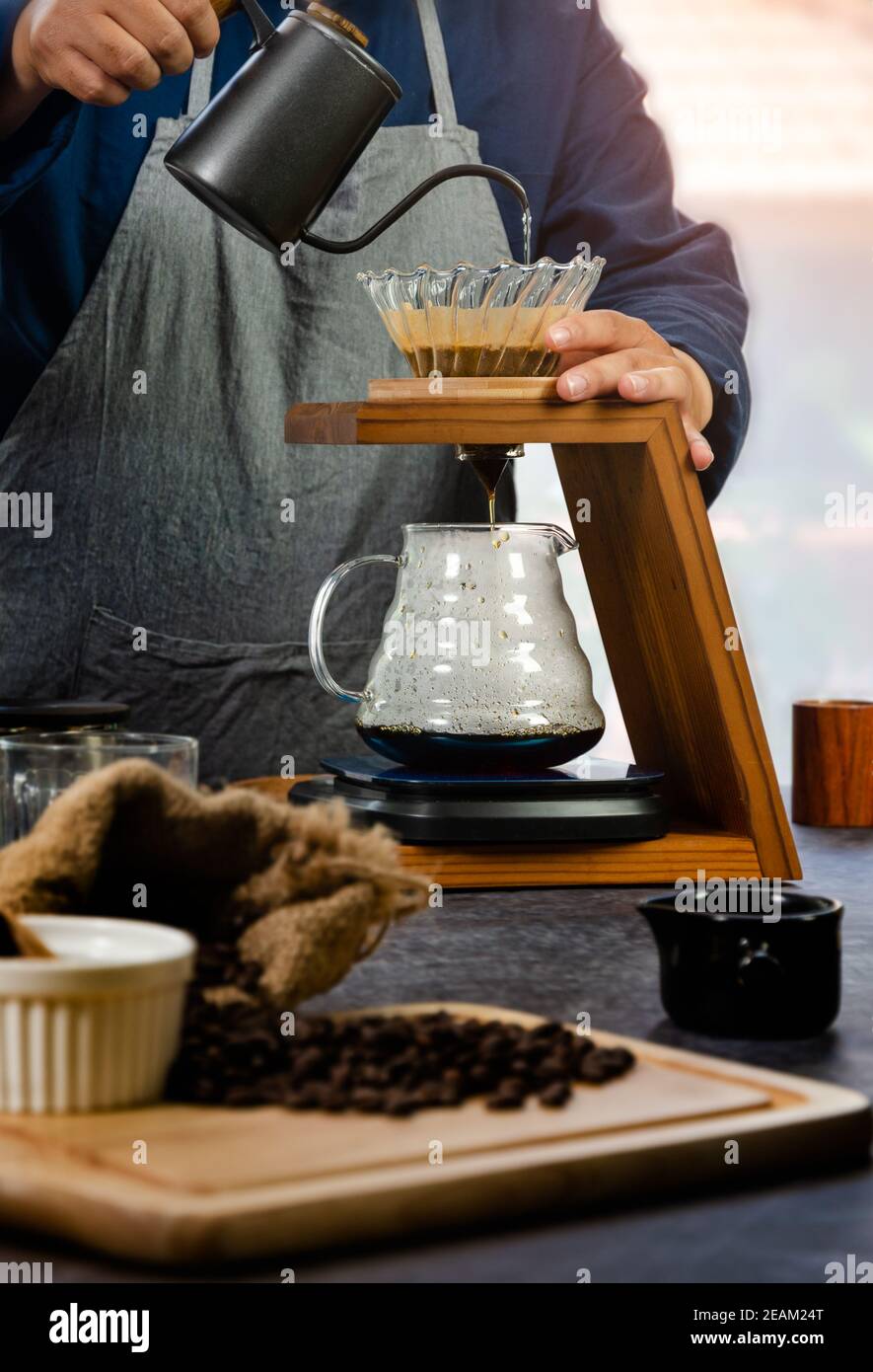 Cafetière. Le barista verse de l'eau chaude sur le café à l'aide d'un filtre en papier. Banque D'Images