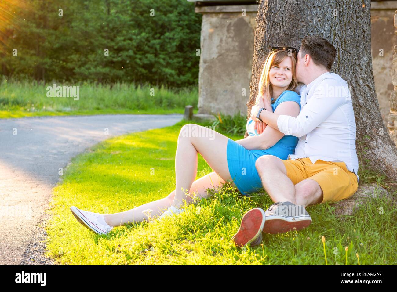 Heureux et amoureux. Jeune couple embrassant sous l'arbre. Couple amoureux couché et embrassant sous l'arbre Banque D'Images