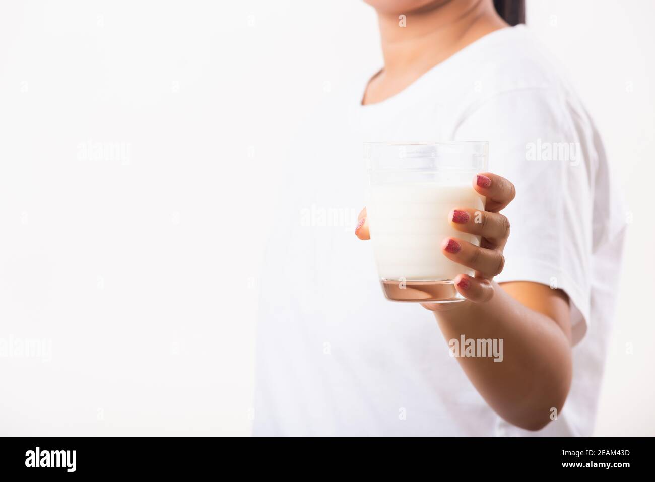 Une femme utilise des mains tenir boire du lait blanc dans un verre Banque D'Images