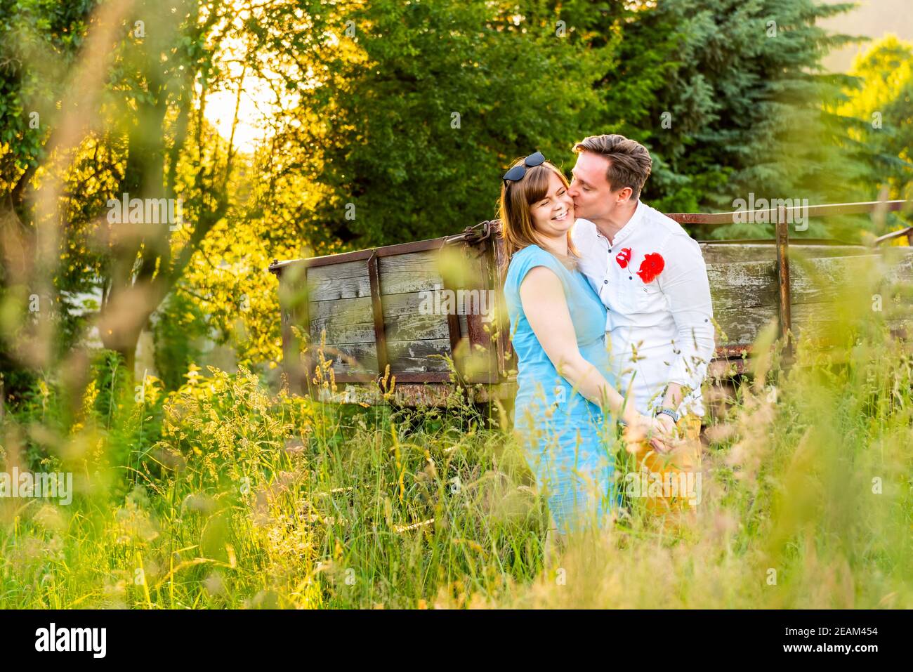 Heureux et amoureux. Jeune couple embrassant sur le champ de prairie dans un village. Banque D'Images