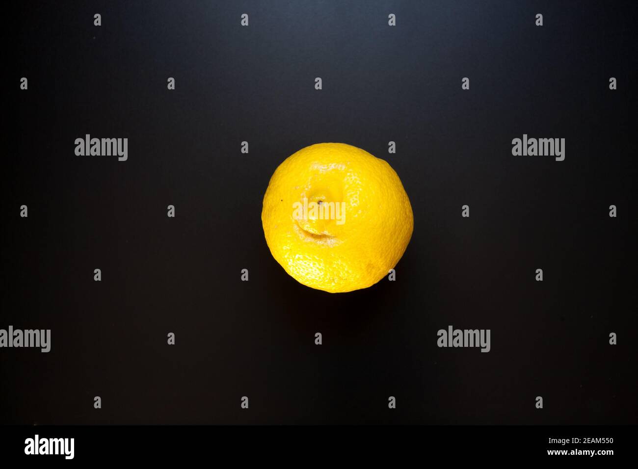 Citron jaune sur table noire, fond de nourriture Banque D'Images