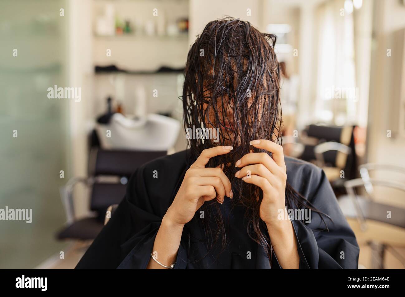 Une cliente pose dans un salon de coiffure Banque D'Images