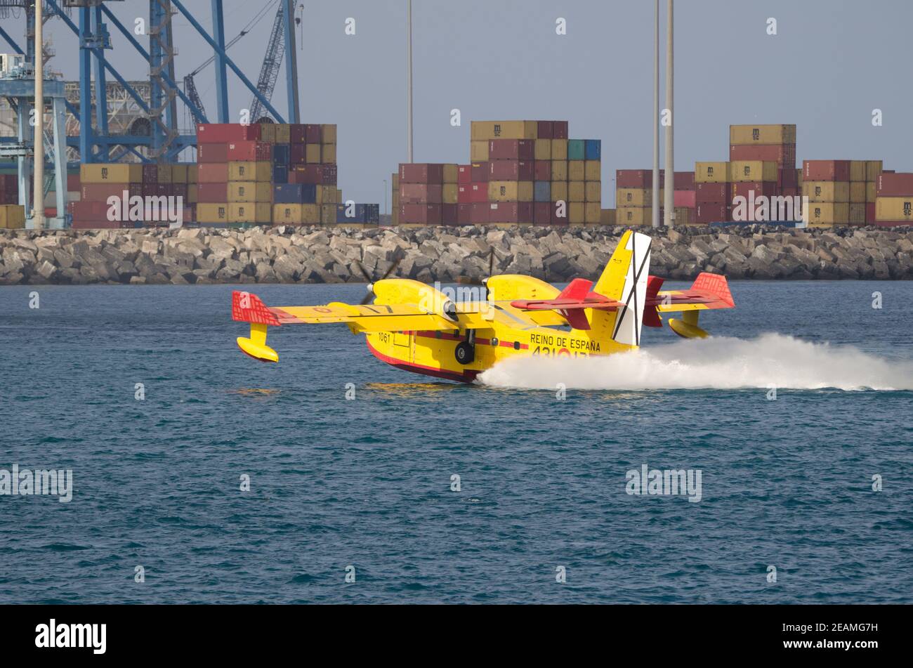 Un avion de lutte contre le feu collectant de l'eau de mer pour éteindre un feu de forêt. Banque D'Images