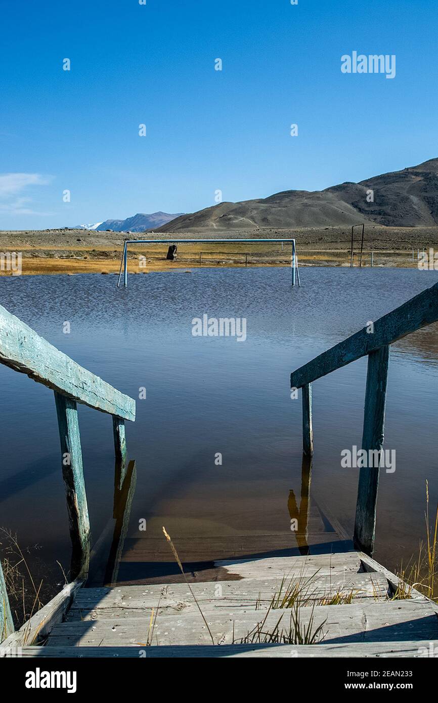 des marches en bois dans le lac descendent. Un stade de football inondé. Banque D'Images