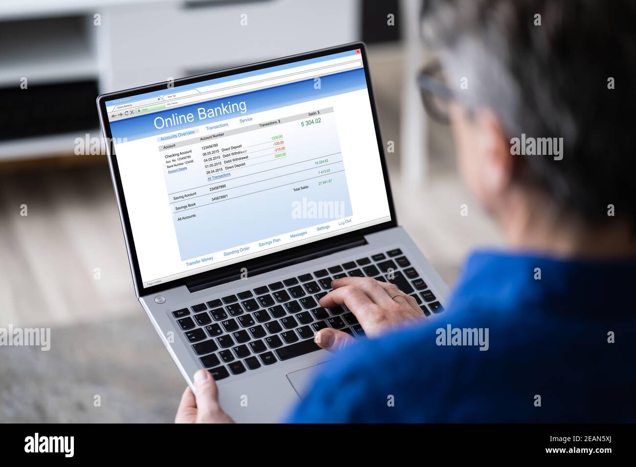 Homme utilisant le relevé de banque de chèques de l'ordinateur tablette Banque D'Images