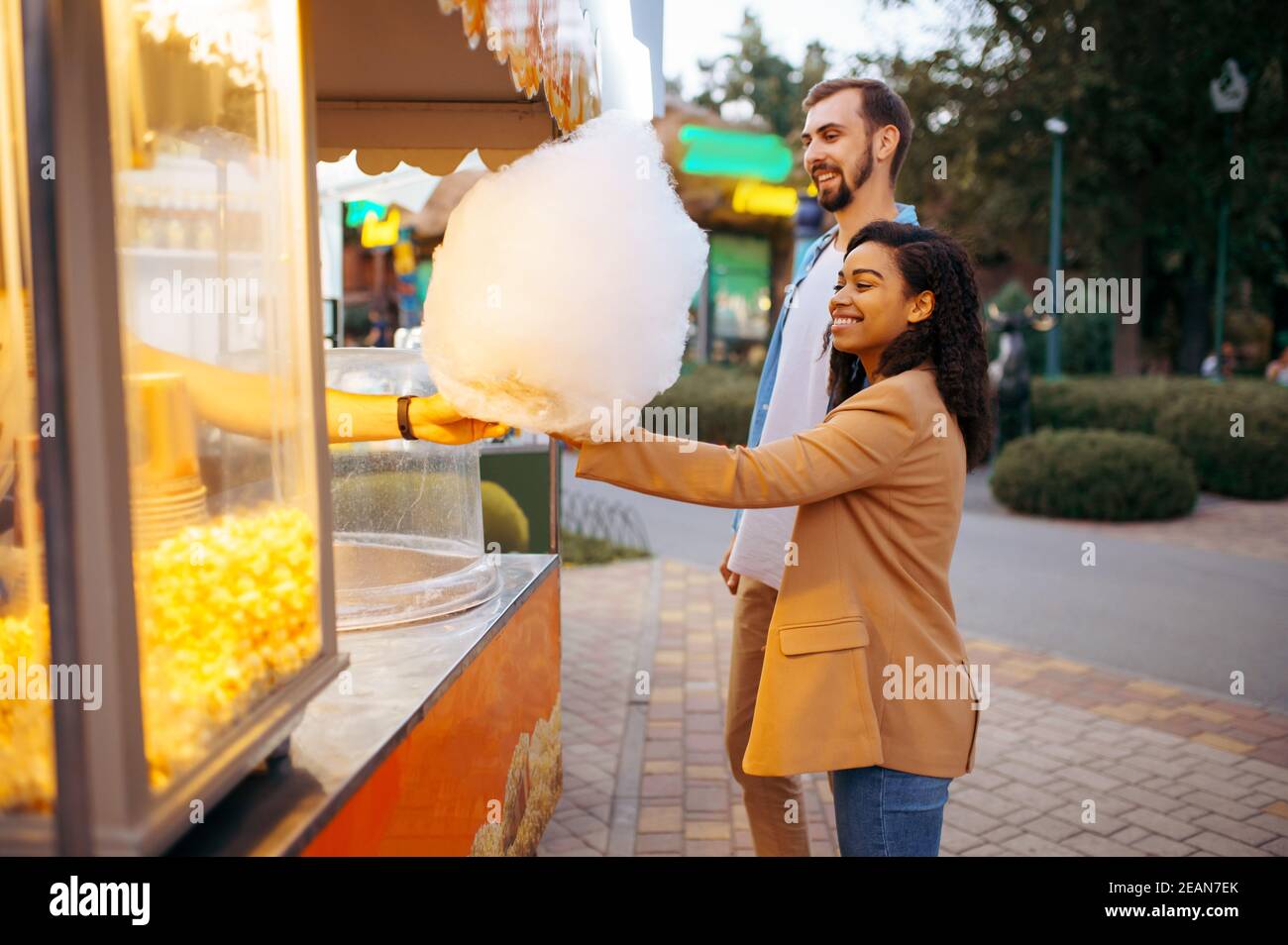 Couple amoureux avec bonbons en coton dans le parc d'attractions Banque D'Images