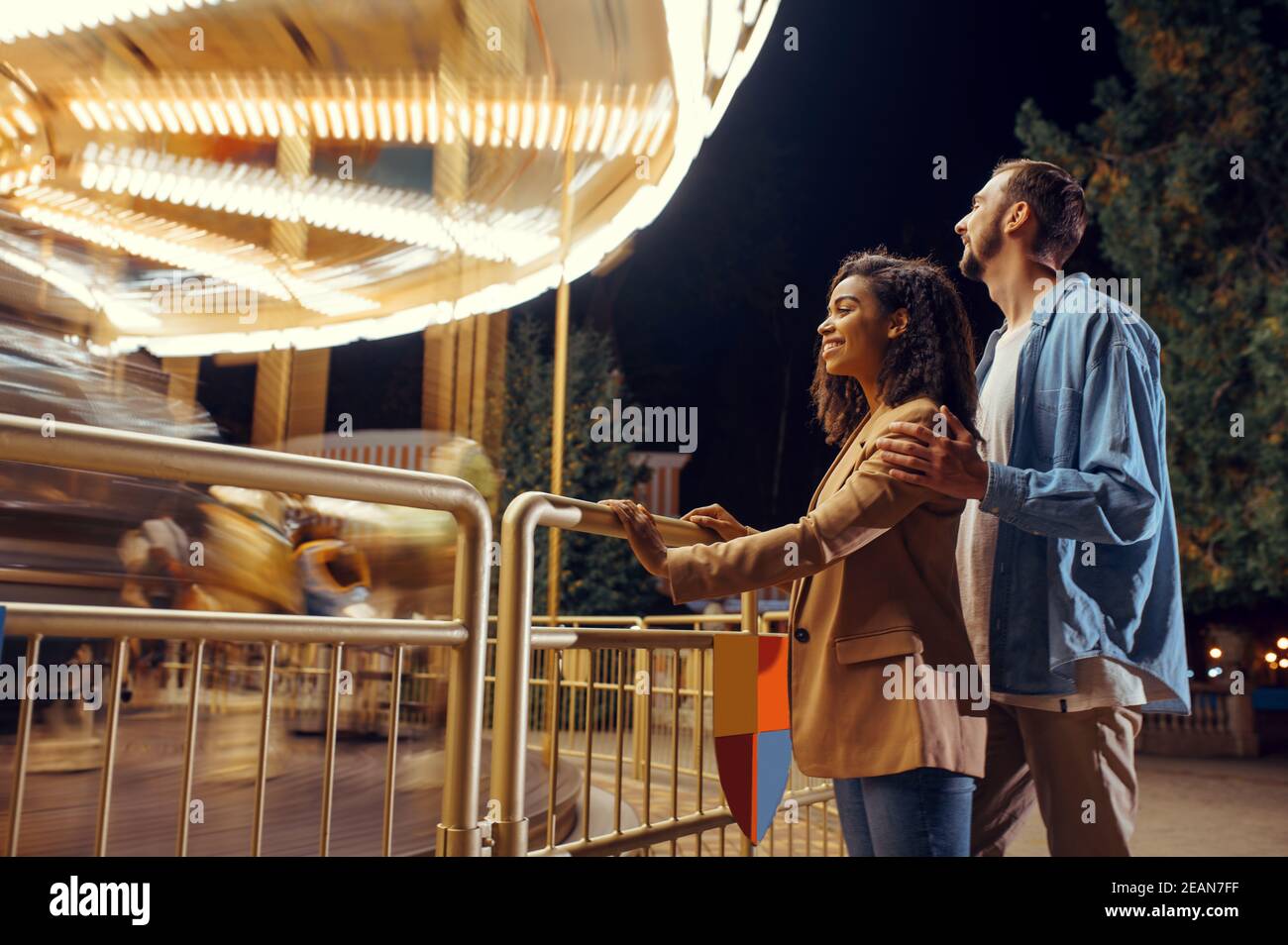Couple au carrousel en mouvement, parc d'attractions Banque D'Images