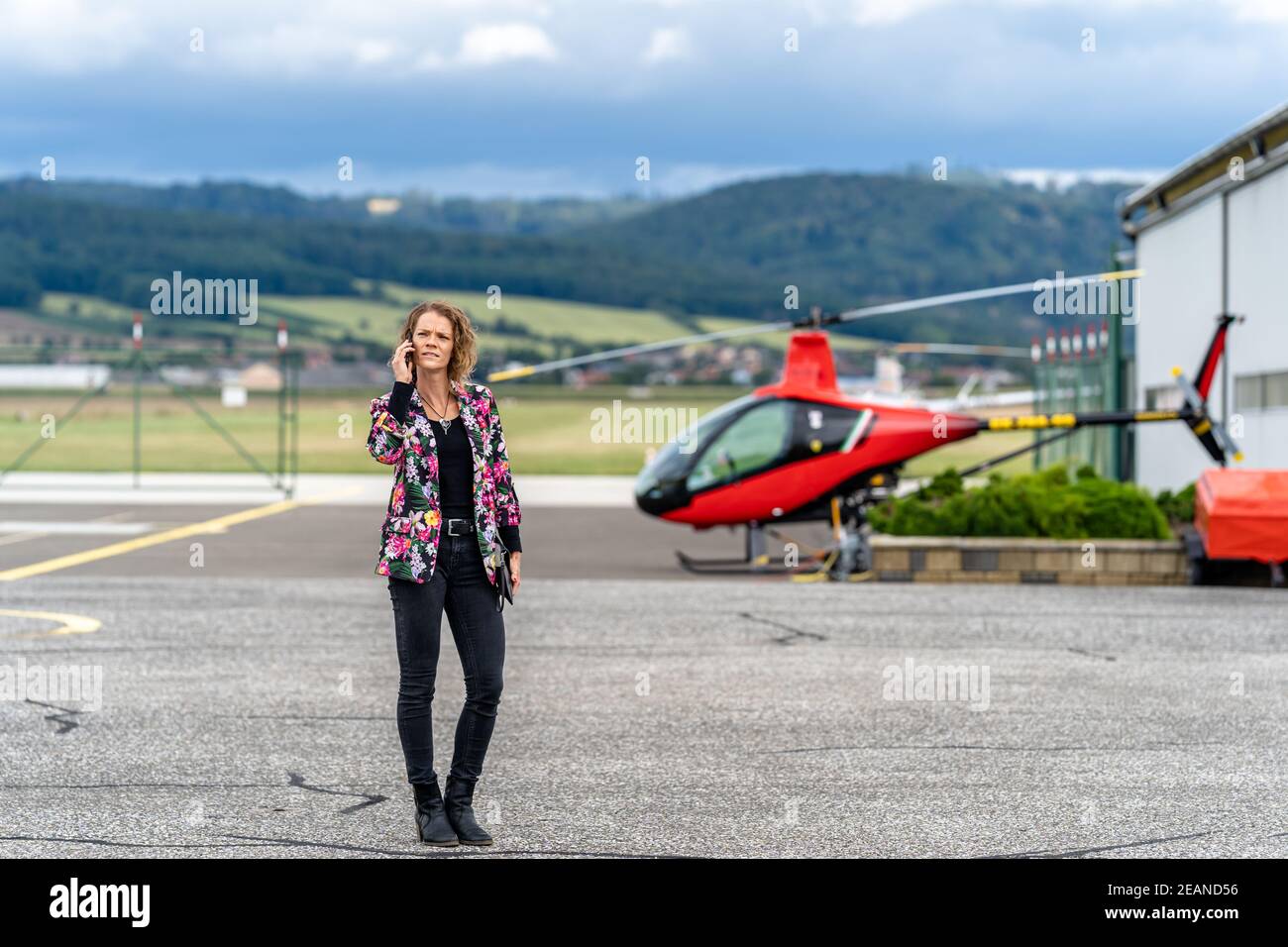 jeune femme d'affaires téléphonant à l'aéroport. transport en hélicoptère Banque D'Images