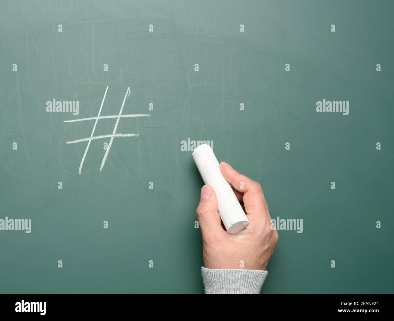 symbole de hashtag femelle dessiné à la main dans la craie blanche sur le vert tableau de craie Banque D'Images