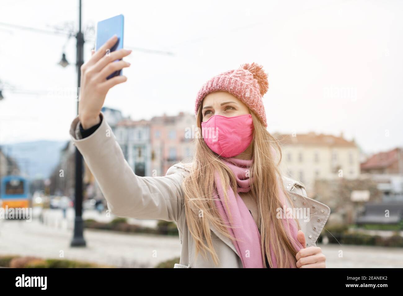 Femme portant un masque corona rendant selfie avec le téléphone Banque D'Images