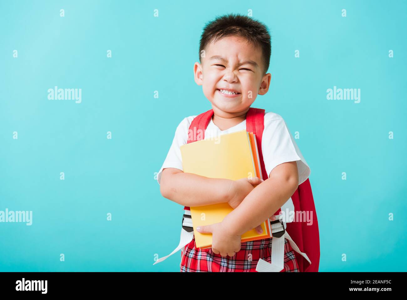 Enfant de la maternelle avec livre et sac d'école Banque D'Images