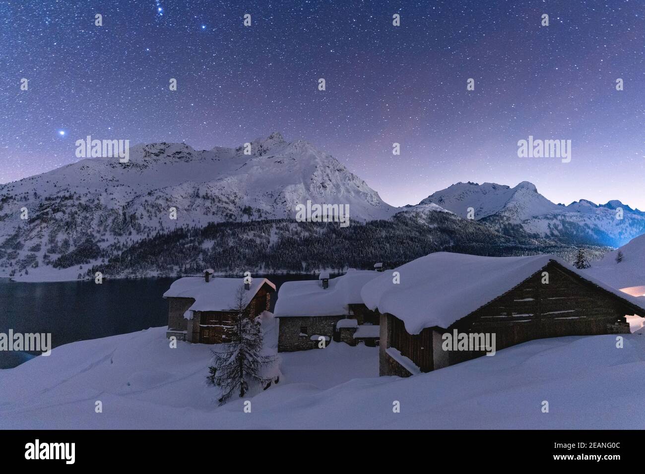 Ciel étoilé au-dessus du pic de Piz Da la Margna et des huttes de Spluga couvertes de neige, Maloja, Engadine, canton de Graubunden, Suisse, Europe Banque D'Images