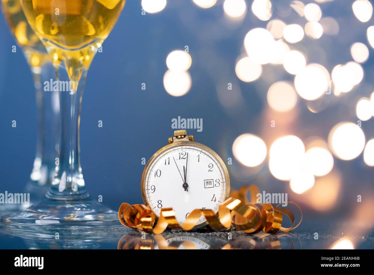 Nouvel an à minuit - horloge ancienne avec décoration de Noël, champagne et lumières de Noël Banque D'Images