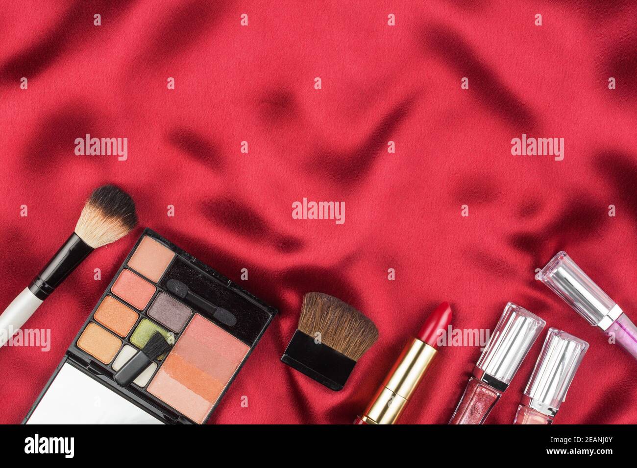 Maquillage pour femmes couché sur de la soie rouge Banque D'Images