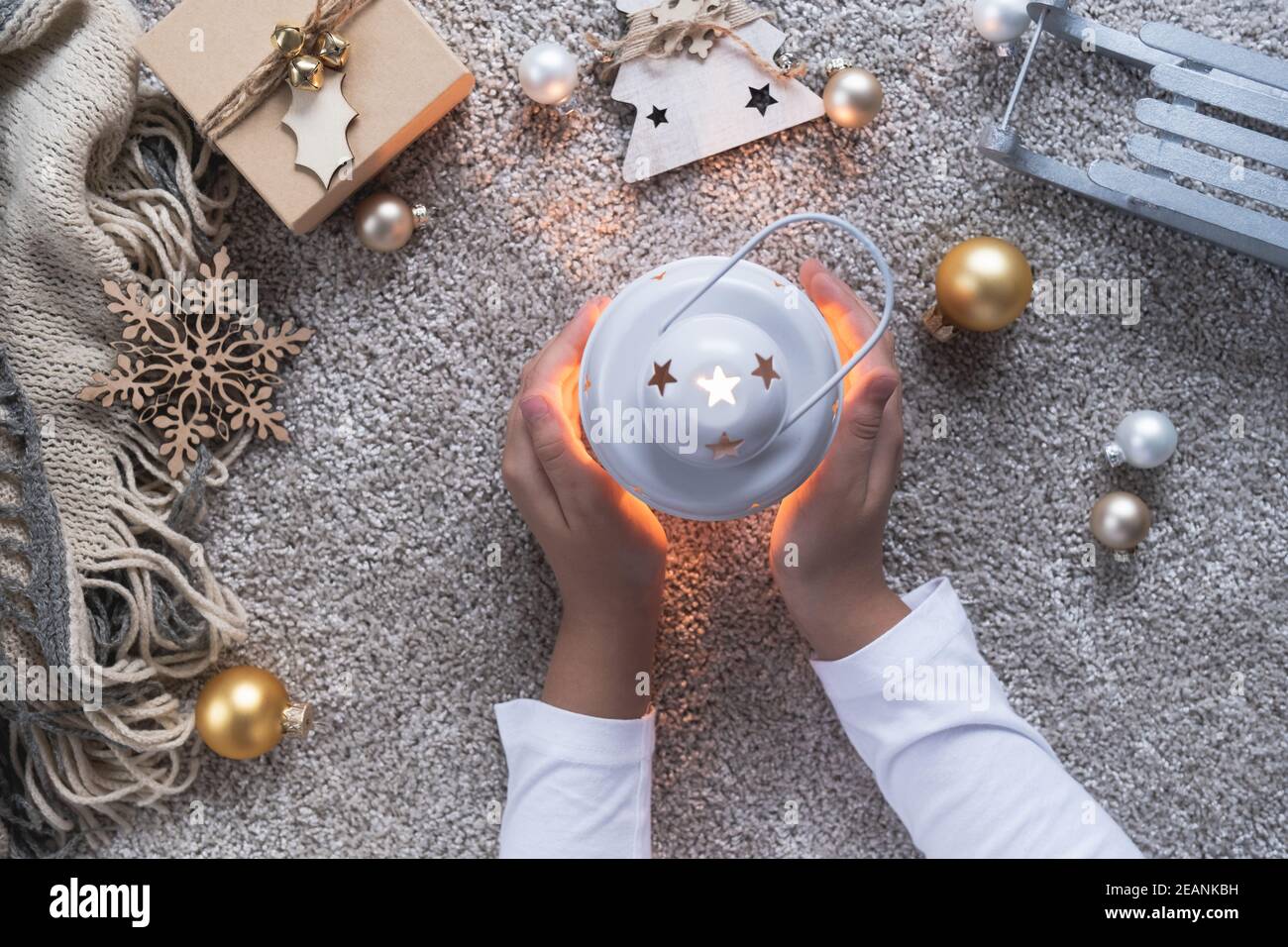 Fond de Noël avec atmosphère d'hiver confortable. Les mains des enfants tiennent la lanterne de noël. Banque D'Images