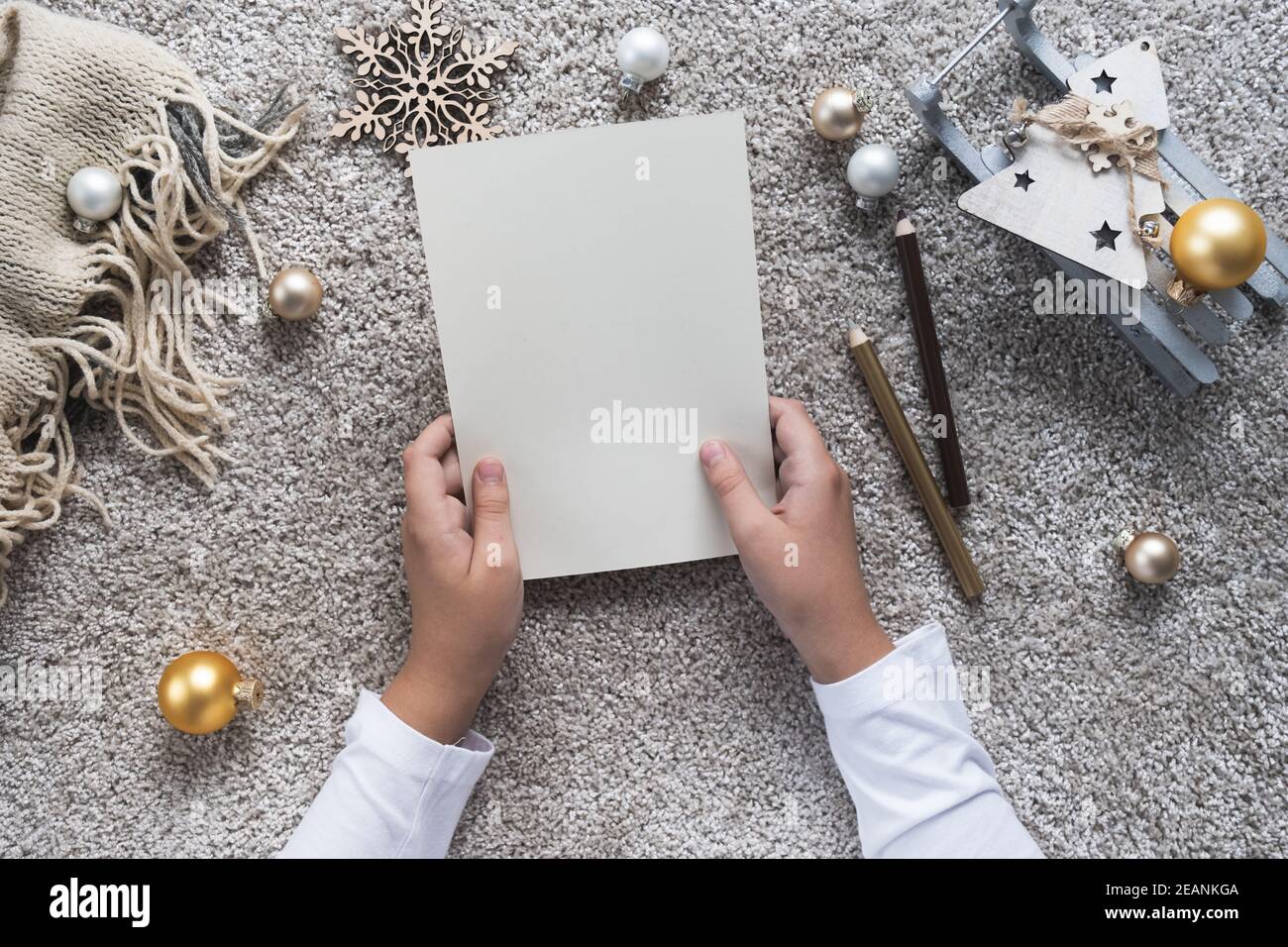 Les mains des enfants écrivent la lettre sur une feuille de papier vide. Concept Noël et nouvel an. Banque D'Images