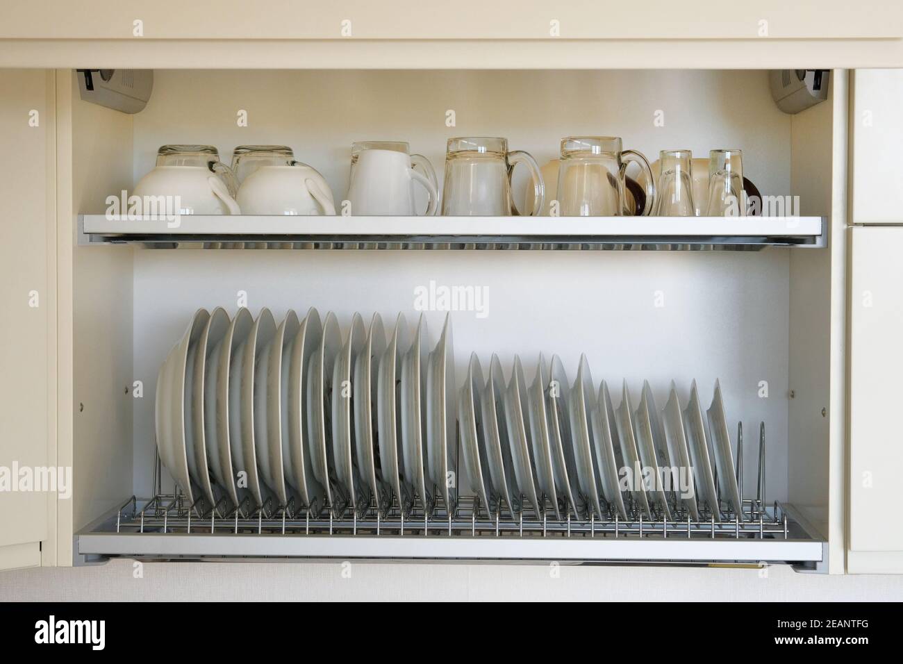 Étagère pour vaisselle séchage dans la cuisine moderne. Vaisselle en verre  blanc et en céramique propre et lavée sur un support en métal à l'intérieur  du placard de cuisine Photo Stock -