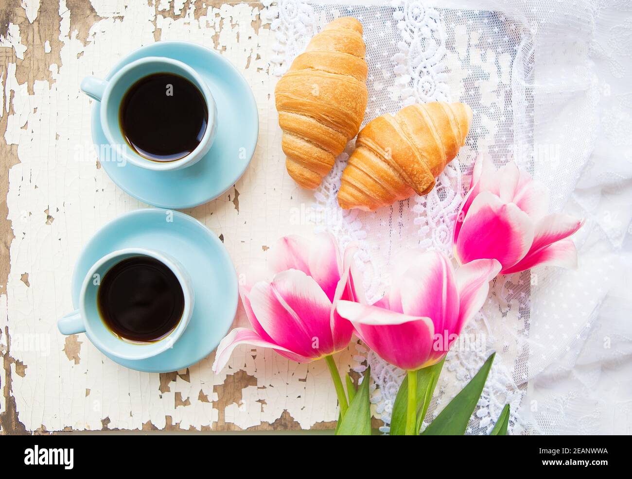 Bonne tasse de café, des croissants et des tulipes roses sur le vieux tableau blanc Banque D'Images