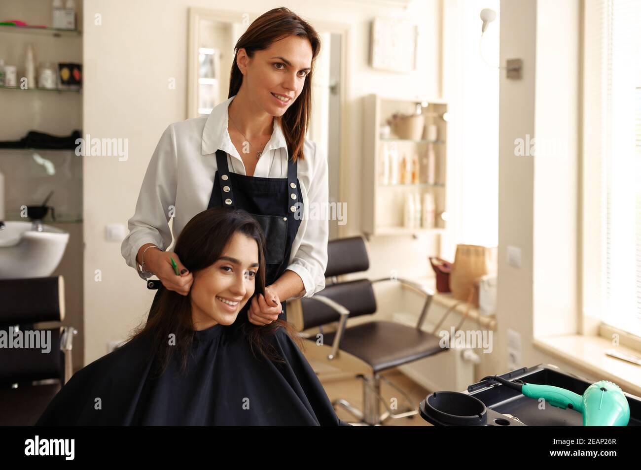 Coiffeur et femme souriante, salon de coiffure Banque D'Images