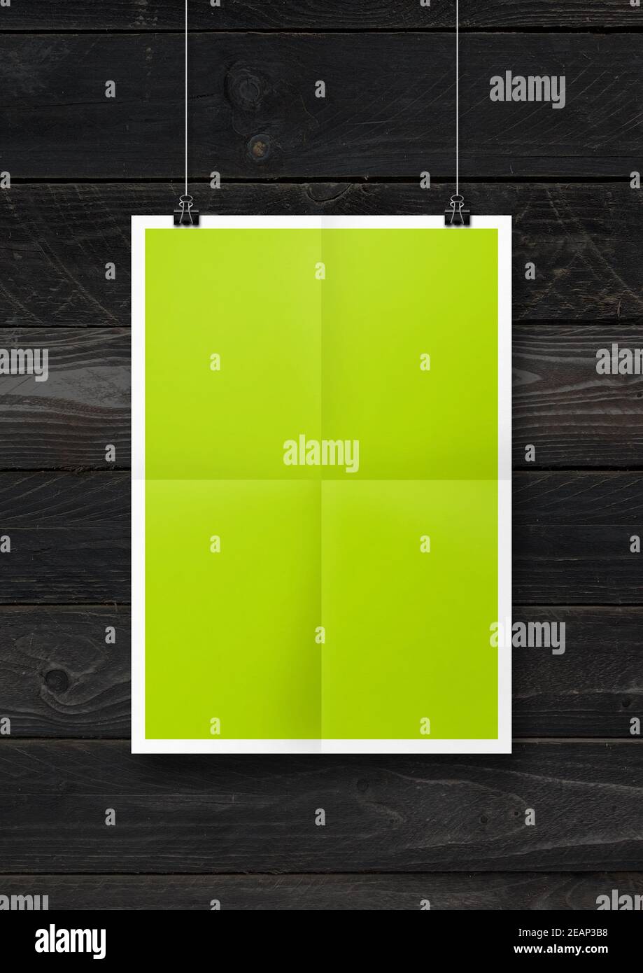 Affiche pliée vert lime suspendue sur un mur en béton avec attaches Banque D'Images