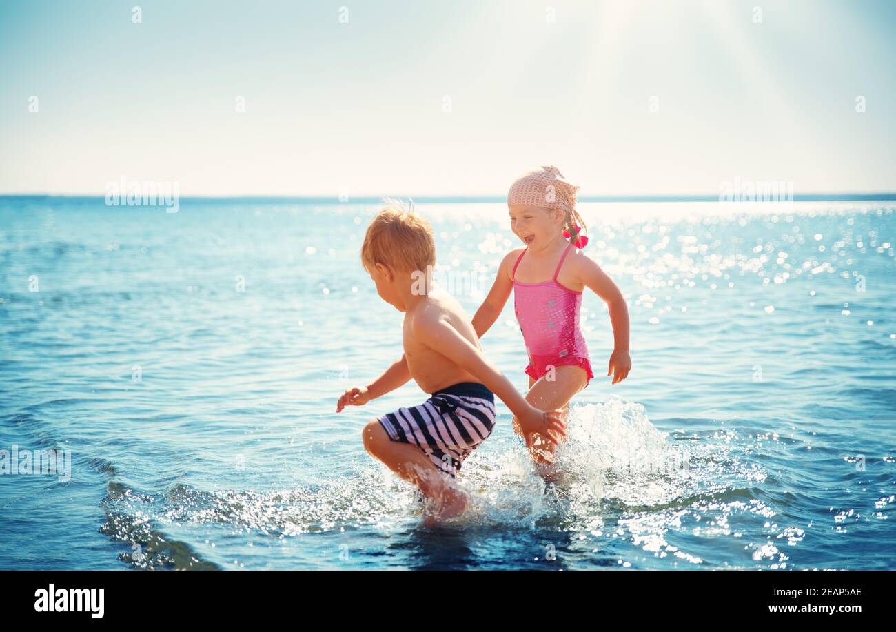 Boy and girl playing on the beach Banque D'Images