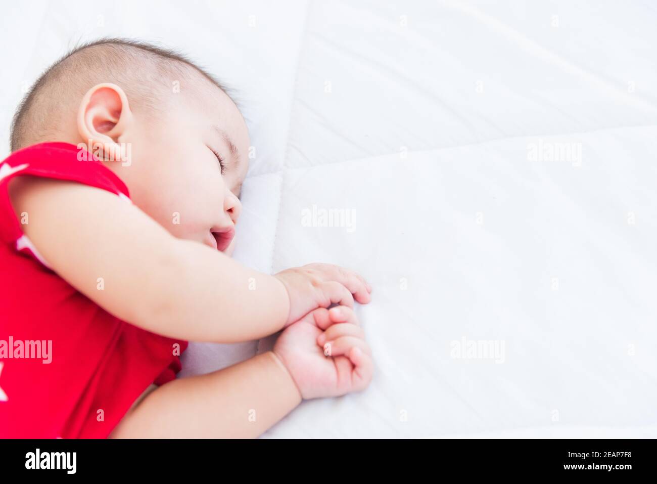 nouveau-né petit bébé dormant sur un lit blanc à la maison Banque D'Images