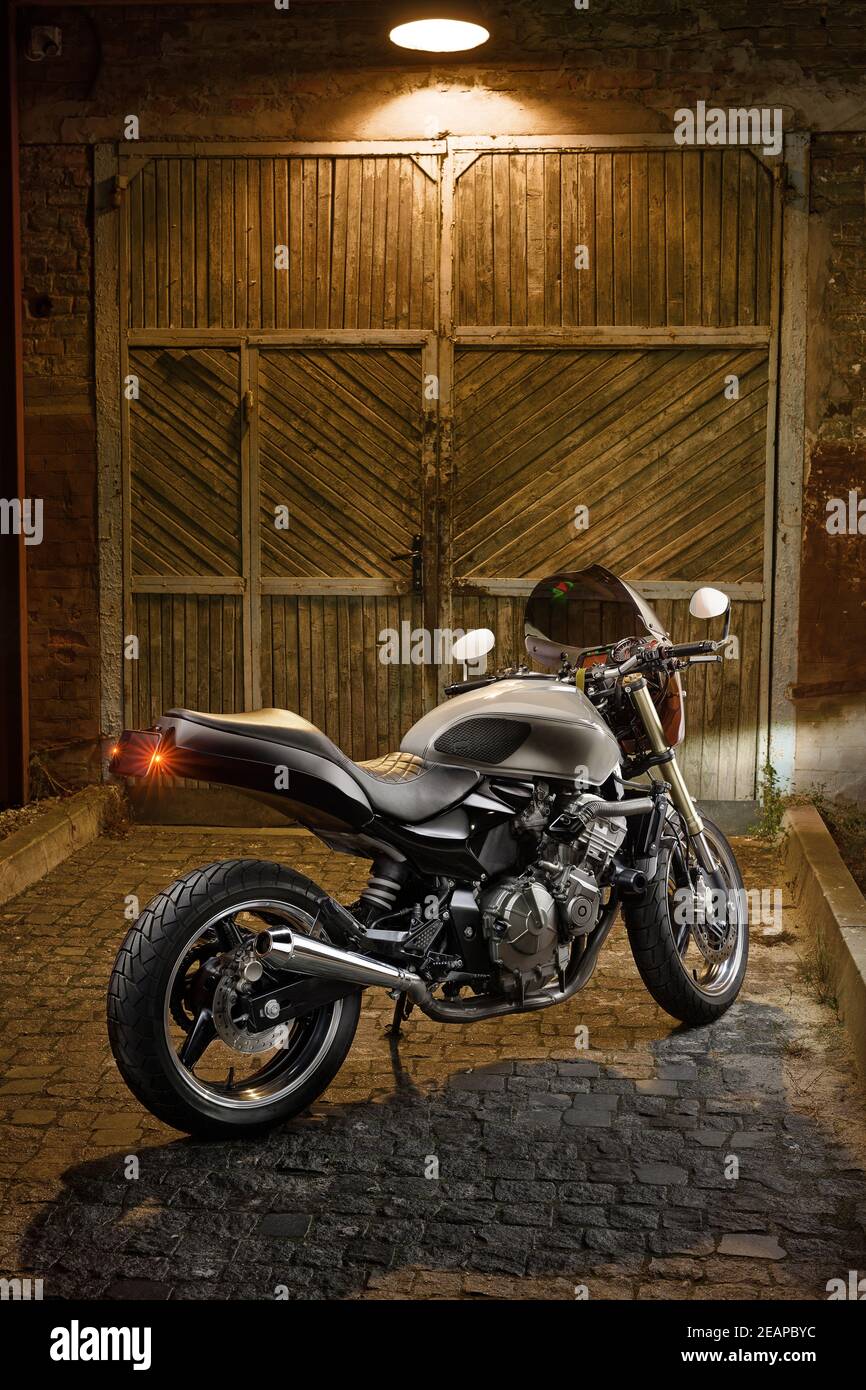 Moto-cafétéria sur mesure sur fond d'une ancienne porte de garage. Banque D'Images