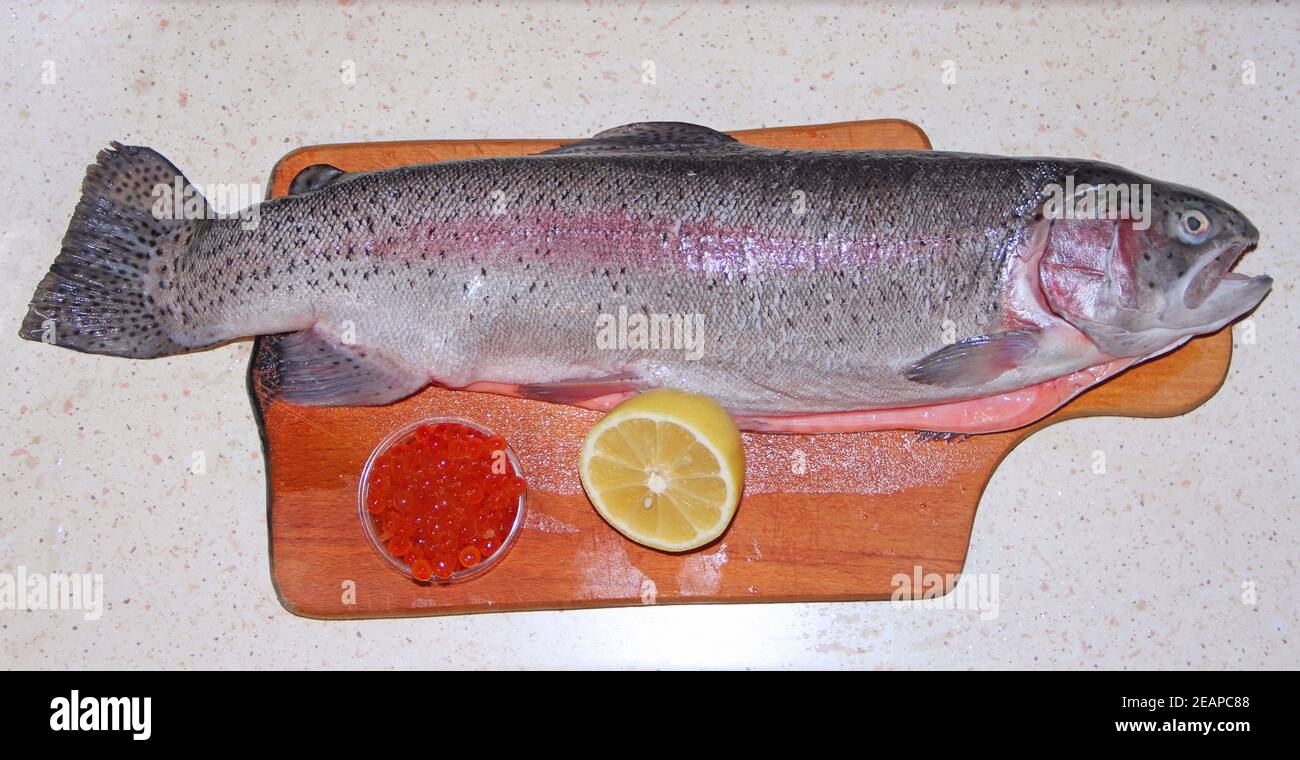 Le caviar rouge de truite arc-en-ciel et le couteau sont prêts à cuire avec du citron. Banque D'Images
