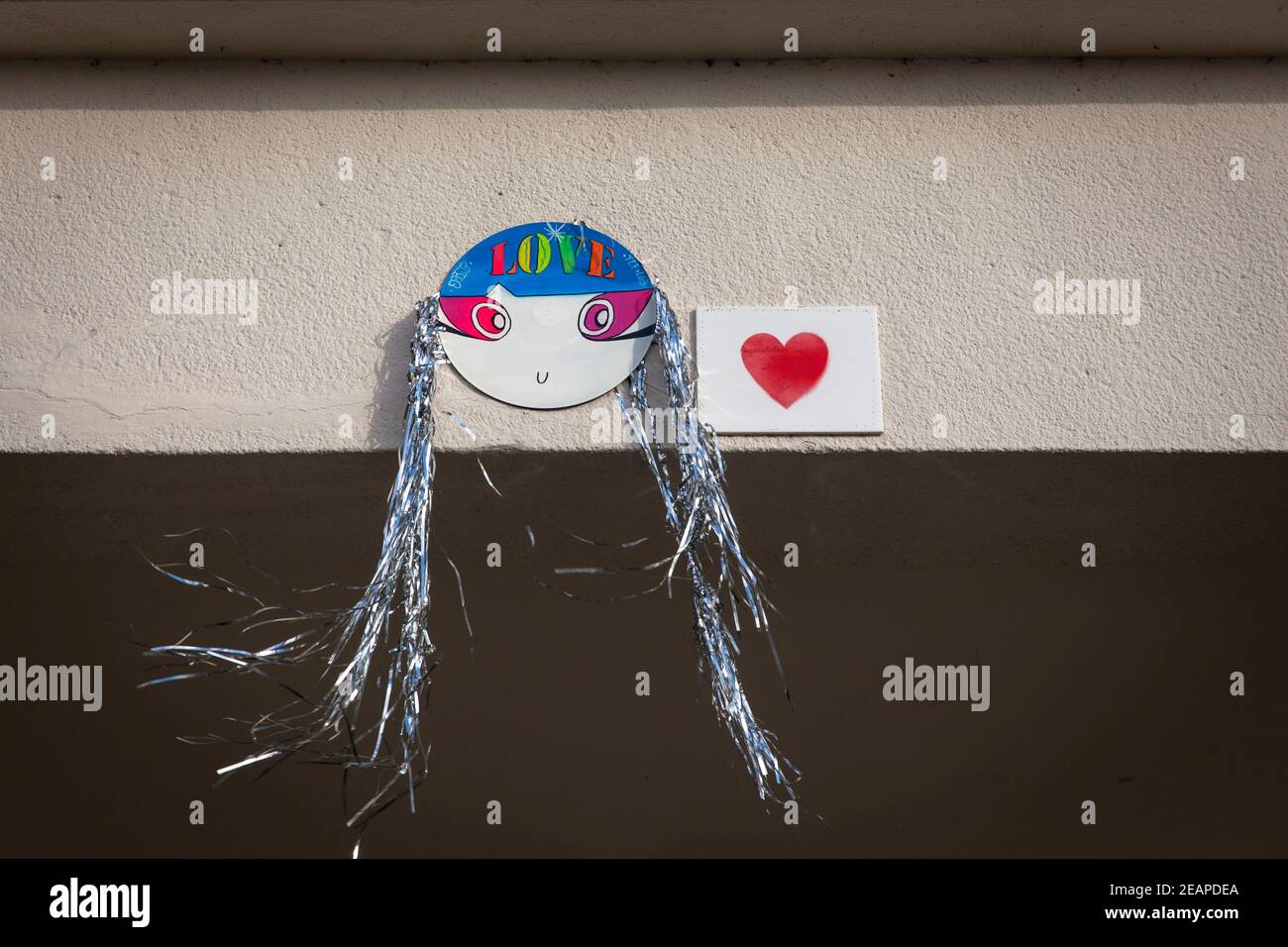 Un visage peint sur carton avec des cheveux tinsels comme une déclaration d'amour, Cologne, Allemagne. ein gemaltes Gesicht auf Pappe mit Lametta-Haaren als Liebe Banque D'Images