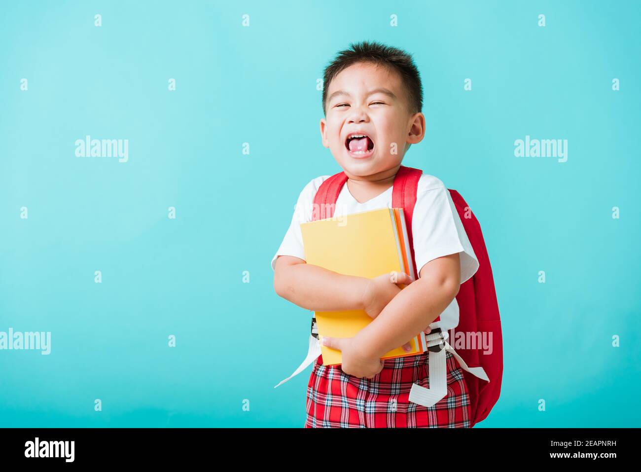 Enfant de la maternelle avec livre et sac d'école Banque D'Images
