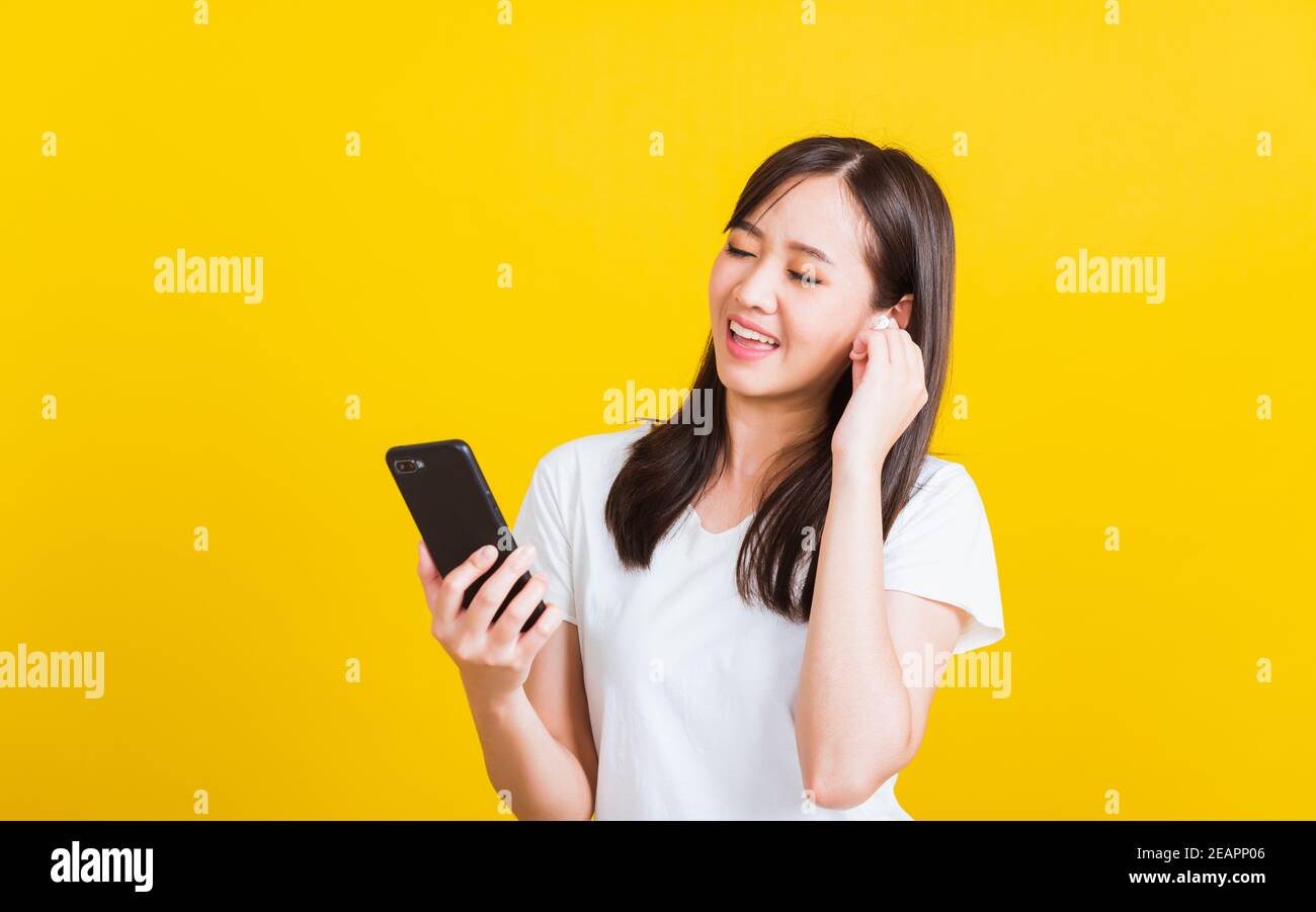 Jeune femme portant un casque sans fil pour écouter de la musique à partir d'un smartphone Banque D'Images