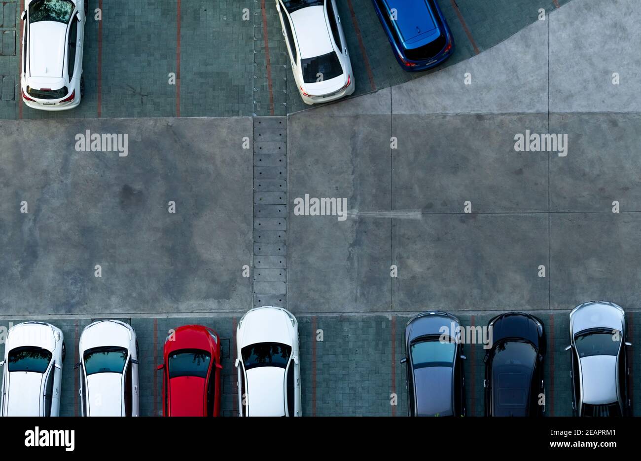 Vue de dessus parking en béton. Vue aérienne de la voiture garée dans le parking de l'appartement. Parking extérieur avec emplacement vide. Panneau de signalisation à sens unique sur la route. Vue ci-dessus à l'extérieur du parking. Banque D'Images