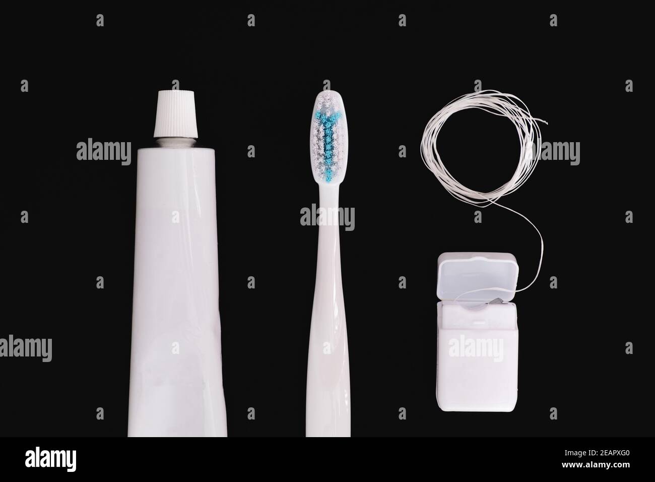 Objets d'hygiène dentaire : brosse à dents, dentifrice et soie dentaire. Accessoires génériques blancs pour garder les dents en santé sur fond noir Banque D'Images