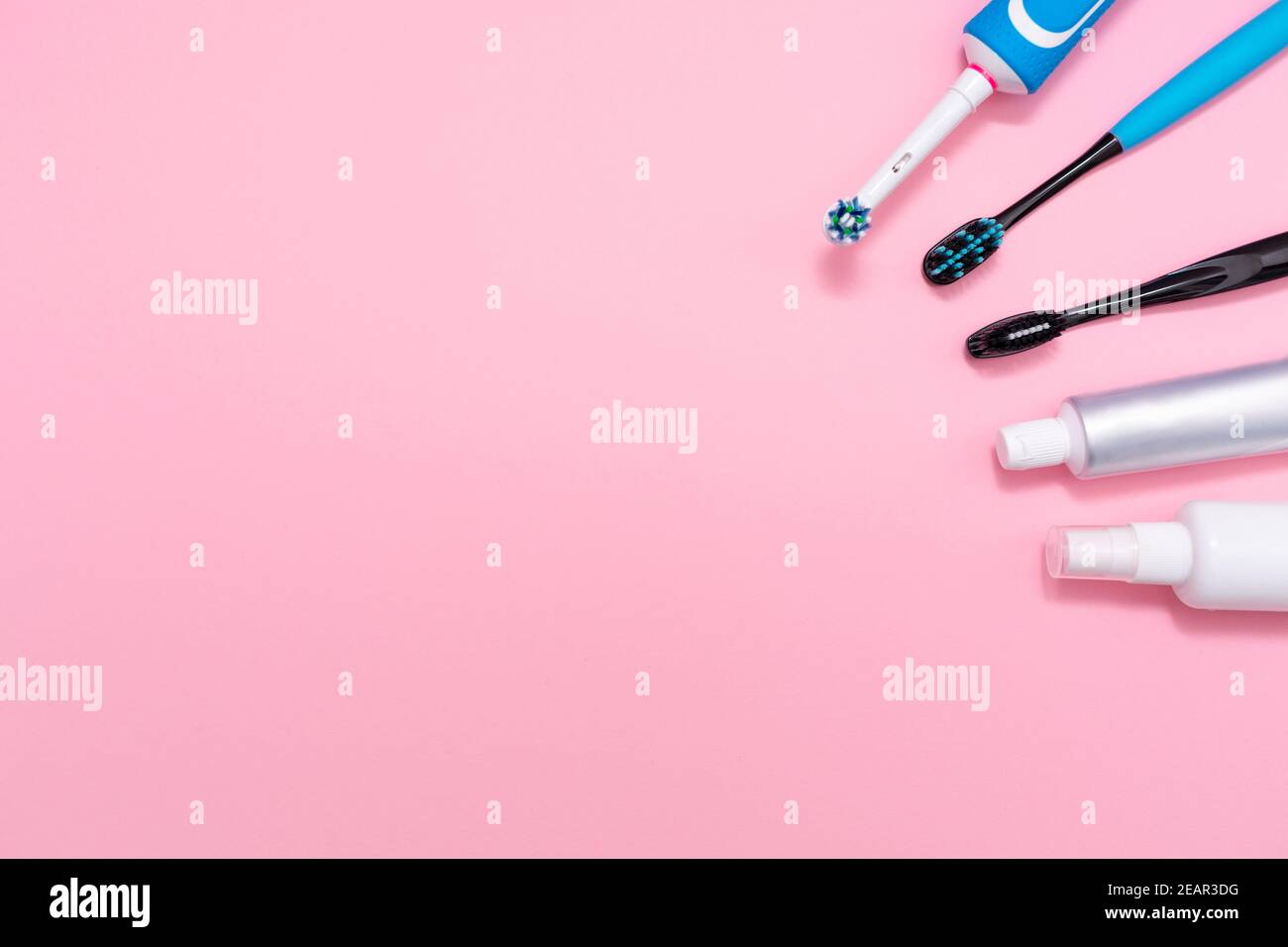 Une brosse à dents électrique et des brosses à dents en plastique, avec dentifrice et désodorisant pour la bouche. Fond rose. Copier l'espace. Concept d'hygiène du cavi oral Banque D'Images