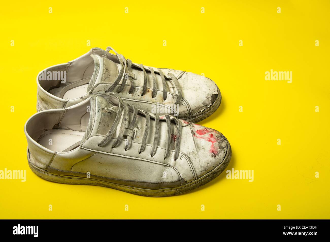 Chaussures sales, sneakers vintage blanc déchiré isolées sur fond jaune  Photo Stock - Alamy