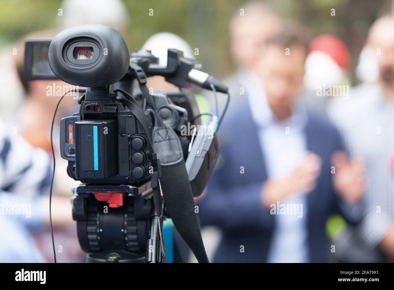 Caméra vidéo dans focus, porte-parole floue en arrière-plan. Conférence de presse. Banque D'Images