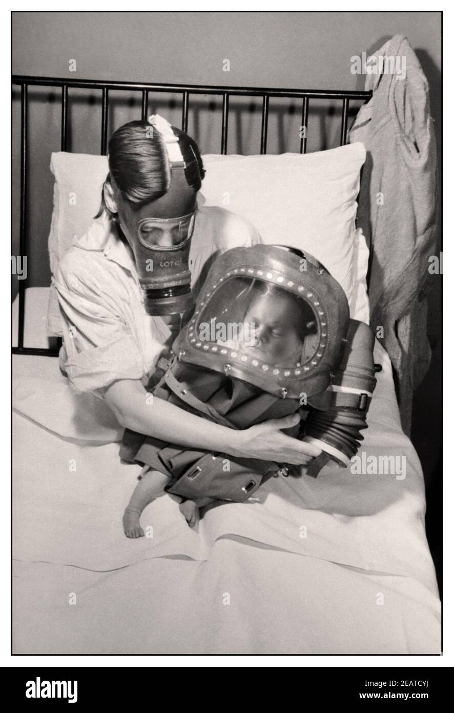 L'ATTAQUE AU GAZ WW2 MASQUE mère et bébé dans des masques à gaz comme précaution contre une attaque au gaz chimique nazi en 1941. Une mère berce son nouveau-né au lit, peu après avoir accouché. La mère porte son respirateur civil, tandis que le bébé est enveloppé dans un casque à gaz, qui se boucle autour du fond du bébé. La mère utilise les soufflets du masque à gaz de son bébé pour pomper l'air du bébé. 1941 Seconde Guerre mondiale Seconde Guerre mondiale Banque D'Images