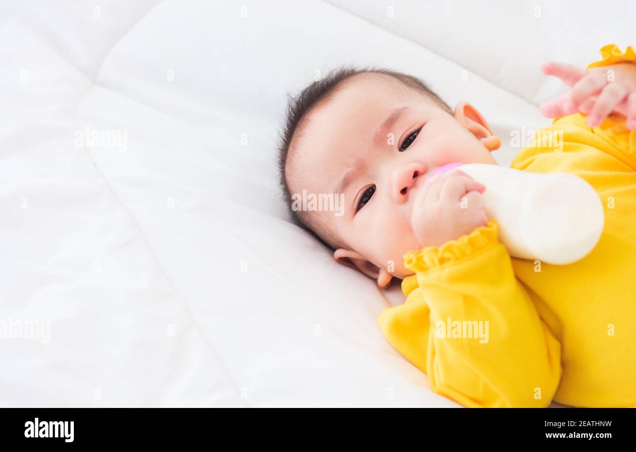 bébé tenant une bouteille de lait Banque D'Images