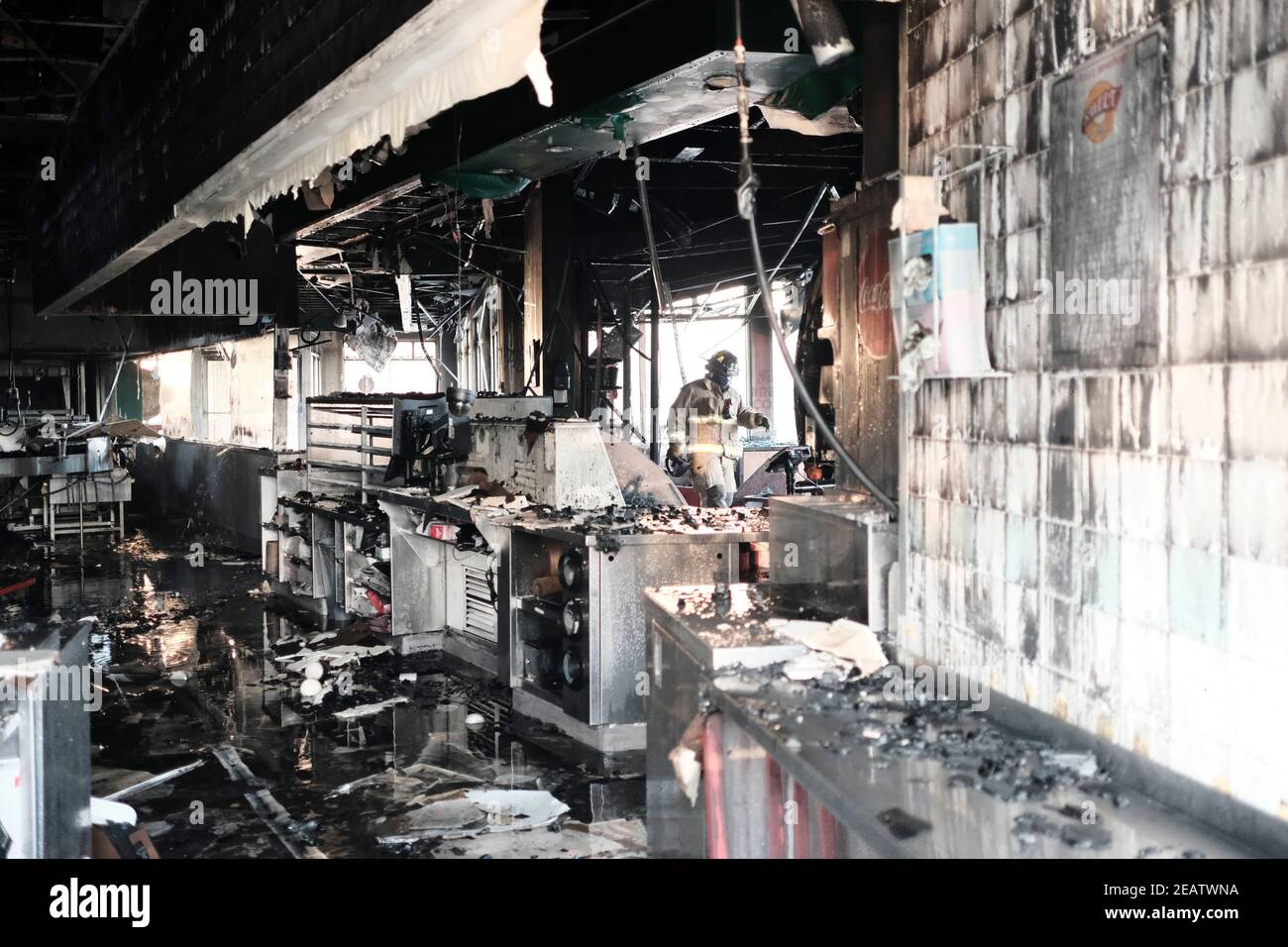 Atlanta, Géorgie, États-Unis. 10 février 2021. Un employé du Service des incendies d'Atlanta traverse l'intérieur d'un magasin de beignets Krispy Kreme sur Ponce de Leon Ave à Atlanta qui a pris feu tôt mercredi matin. La boutique a été construite en 1965 et depuis des années a été un point de repère. La salle NBA de famer Shaquille O'Neal est devenue propriétaire de la boutique en 2016. Crédit : John Arthur Brown/ZUMA Wire/Alay Live News Banque D'Images