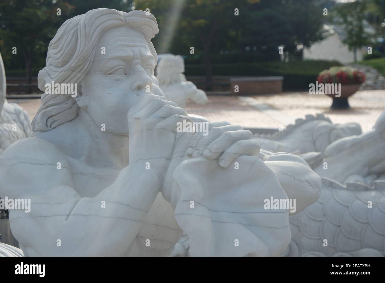 Sculpture en pierre d'un Triton, soufflant sur sa trompette de coquille de conch. Banque D'Images