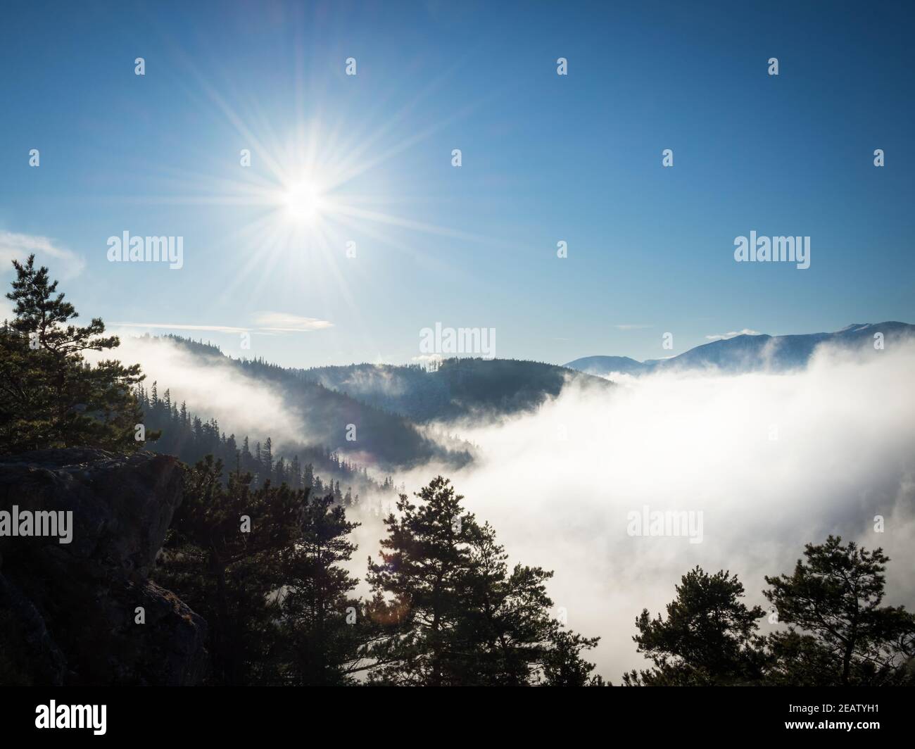 Rayons de soleil sur la crête de montagne avec un peu de brouillard d'inversion dans le vallées Banque D'Images