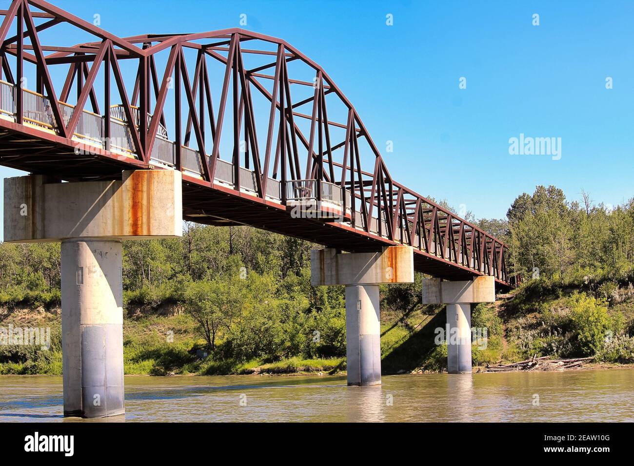 Un pont à pied au-dessus d'une rivière en été Banque D'Images