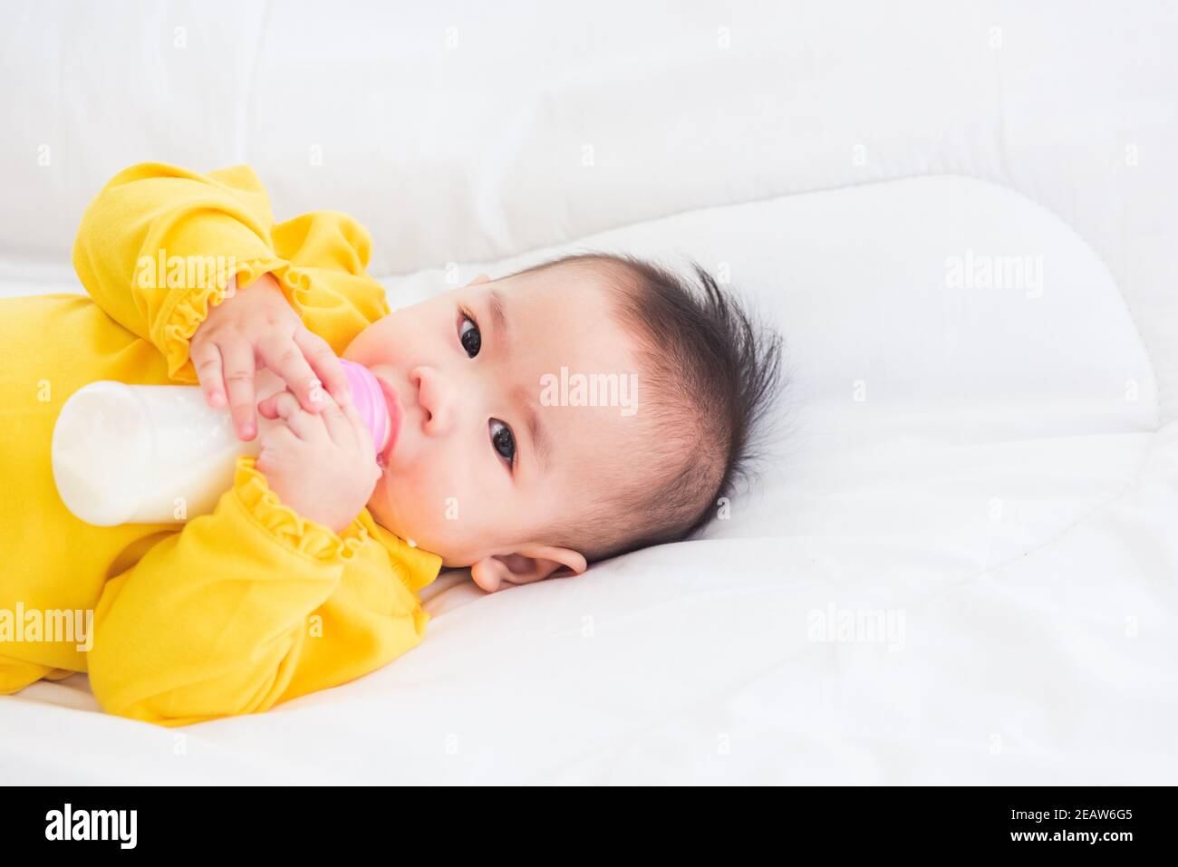 bébé tenant une bouteille de lait Banque D'Images