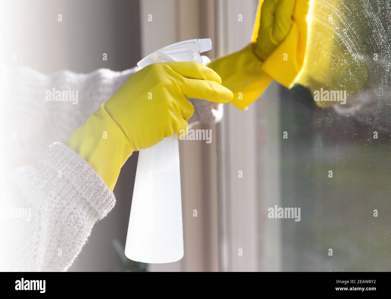 Nettoyage d'une fenêtre avec un détergent en aérosol, des gants en caoutchouc jaune et un chiffon à vaisselle sur la surface de travail concept pour l'hygiène, l'entreprise et la santé concept Banque D'Images